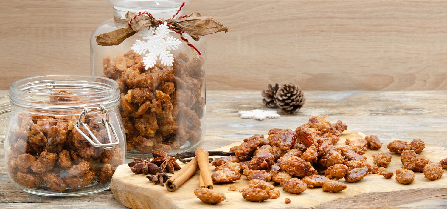 Gebrannte Mandeln in Gläsern und auf einer Holzplatte