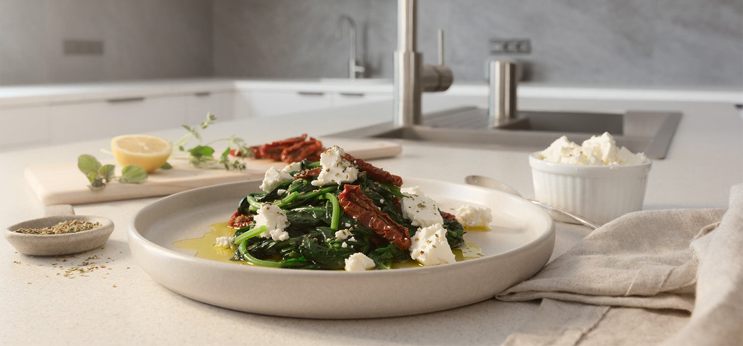 gekochter Spinat mit zerbröseltem Feta, getrockneten Tomaten und Oregano