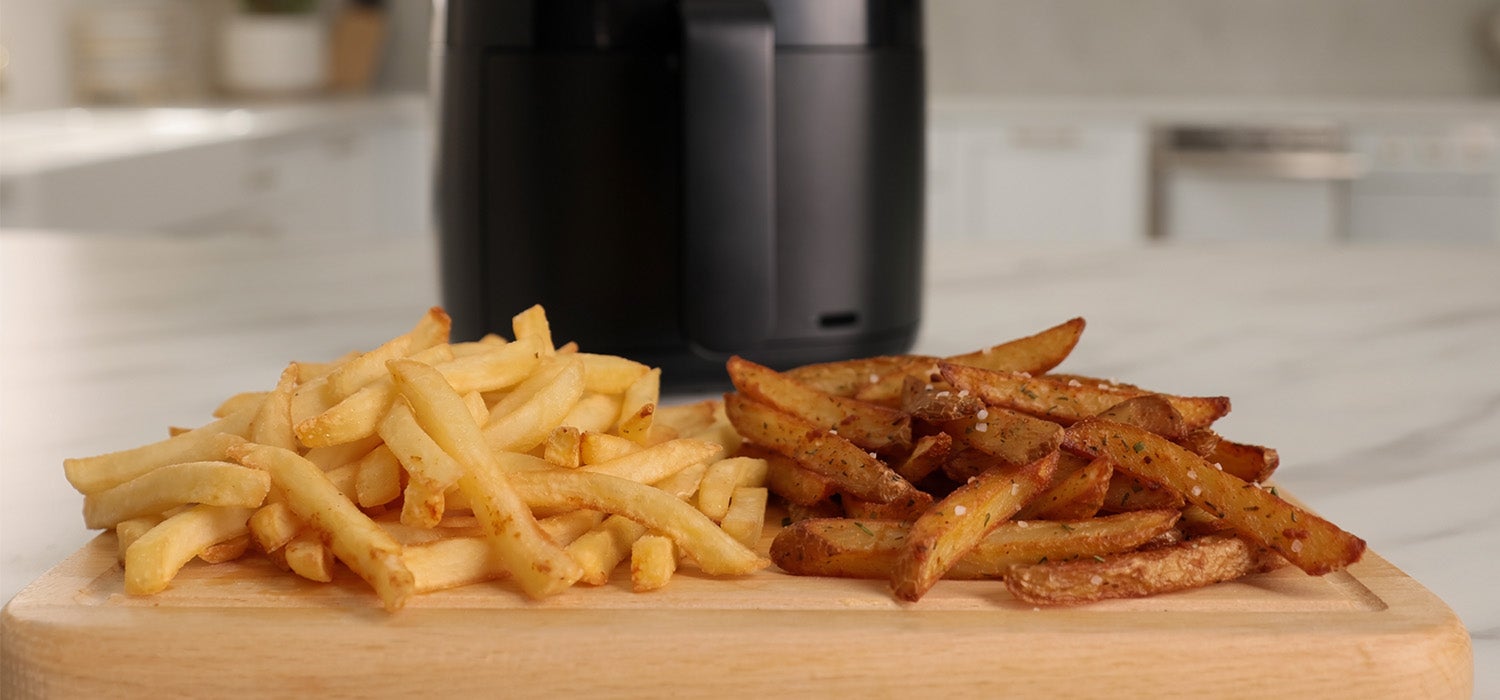 tiefkühlpommes neben selbstgemachten pommes, dahinter ein Airfryer