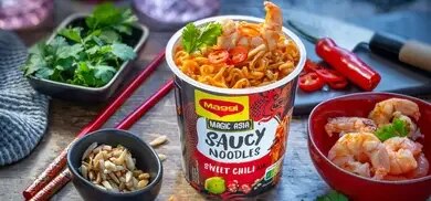 Maggi Saucy Noodles Becher mit Garnelen, rote Chili, Koriander, Schälchen mit Garnelen und Nüssen, Essstäbchen
