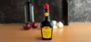 Fokussierte Abbildung der MAGGI Original Würze auf einer Tischplatte.