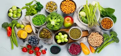 Brokkoli, Rosenkohl, Spargel, Kichererbsen, Bohnen, Erbsen, Mandeln und weiteres Gemüse auf Tisch