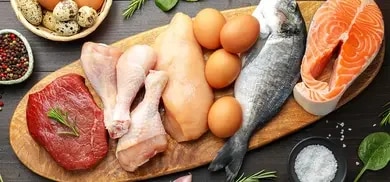 Lachs, ganzer Fisch, Rindfleisch, Hähnchenfleisch, Eier und Wachteleier auf Holzbrett