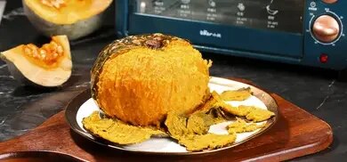 Gegarter Kürbis auf Teller mit abgelöster Schale vor Backofen.