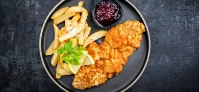 leckeres Schnitzel mit Pommes und Preiselbeeren als leckere Beilage
