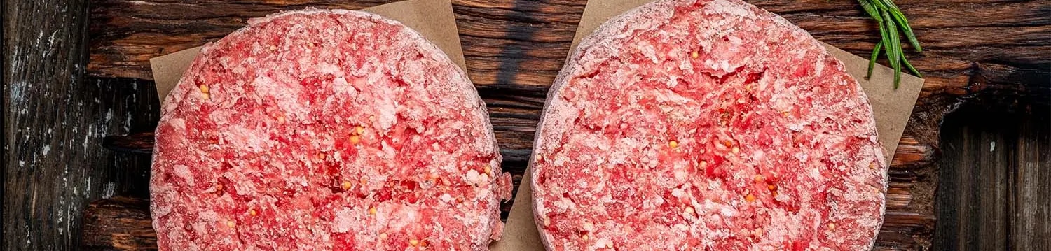 Hackfleisch schnell auftauen – gefrorene Burger-Patties auf Holzbrett