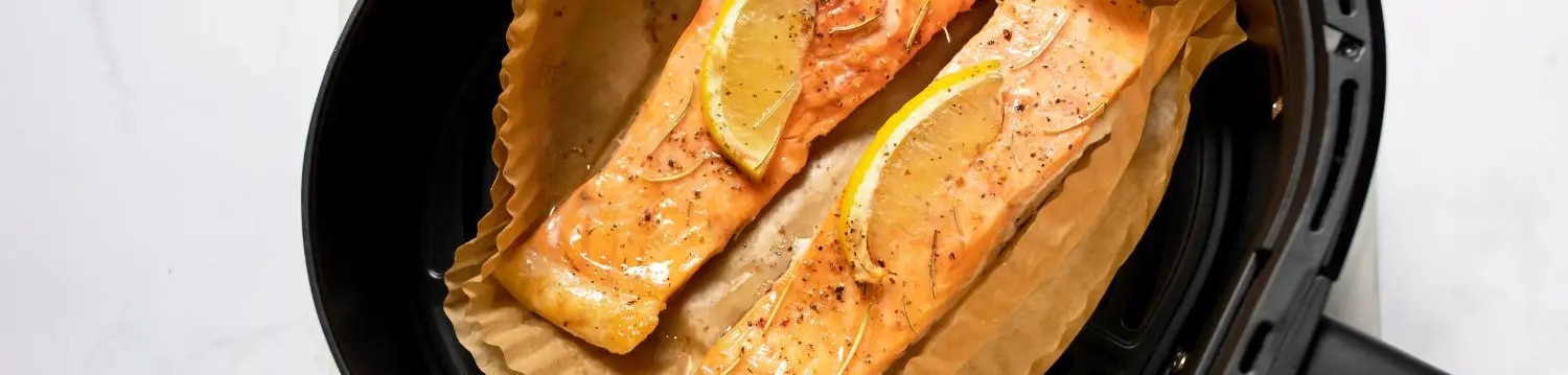 Lachs auf Backpapier in Heißluftfritteuse