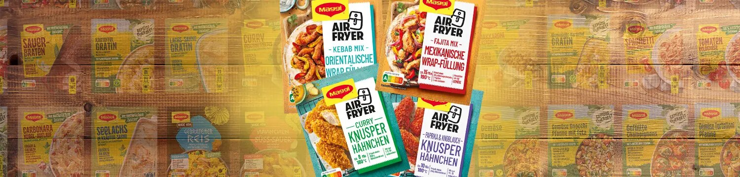 Vier Maggi Airfryer Fix Packungen für Wrap Füllung und Knusperhähnchen auf Holz, Hintergrund mit weiteren Produkten