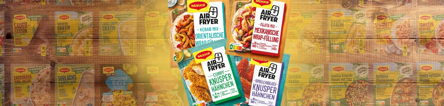 Vier Maggi Airfryer Fix Packungen für Wrap Füllung und Knusperhähnchen auf Holz, Hintergrund mit weiteren Produkten