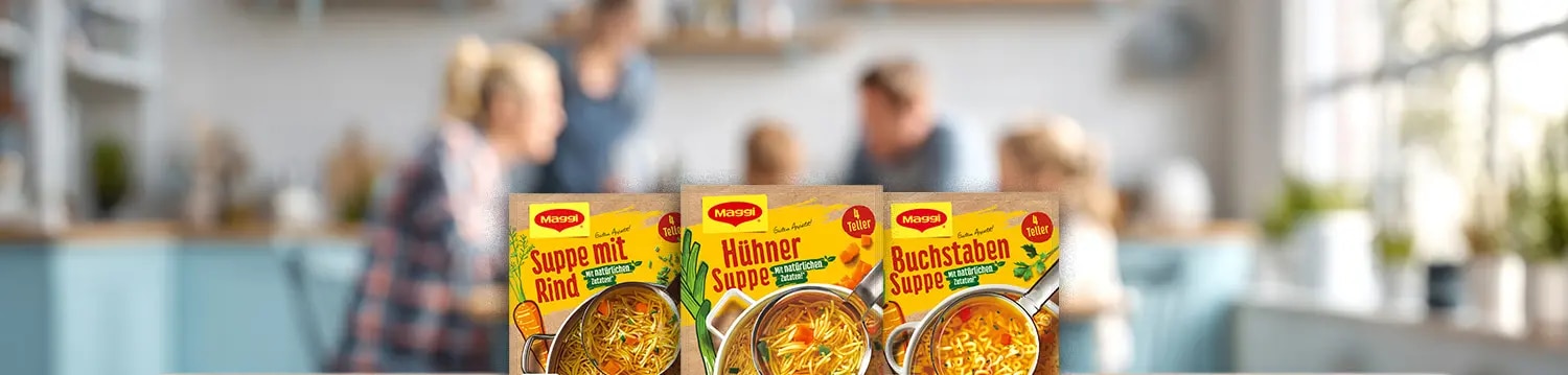 Drei Maggi Suppenverpackungen mit Rind-, Huehner- und Buchstabensuppe auf Holztisch vor Kuechenhintergrund
