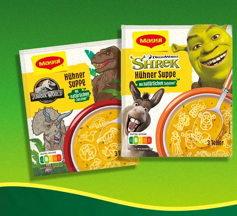 Zwei Maggi Hühnersuppe Packungen mit Shrek und Jurassic World, rechts Schriftzug So lecker, so spaßig auf grünem Hintergrund
