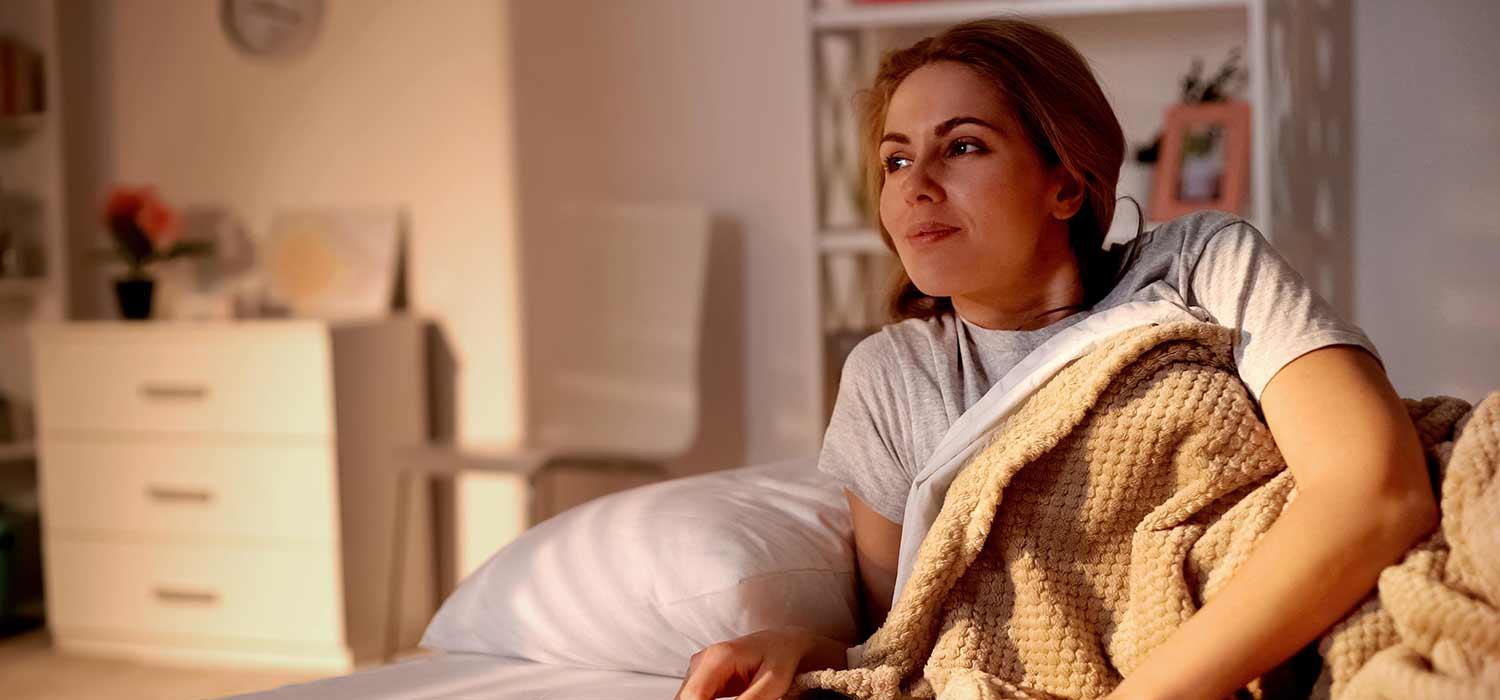 Frau im Bettkurz vorm aufstehen