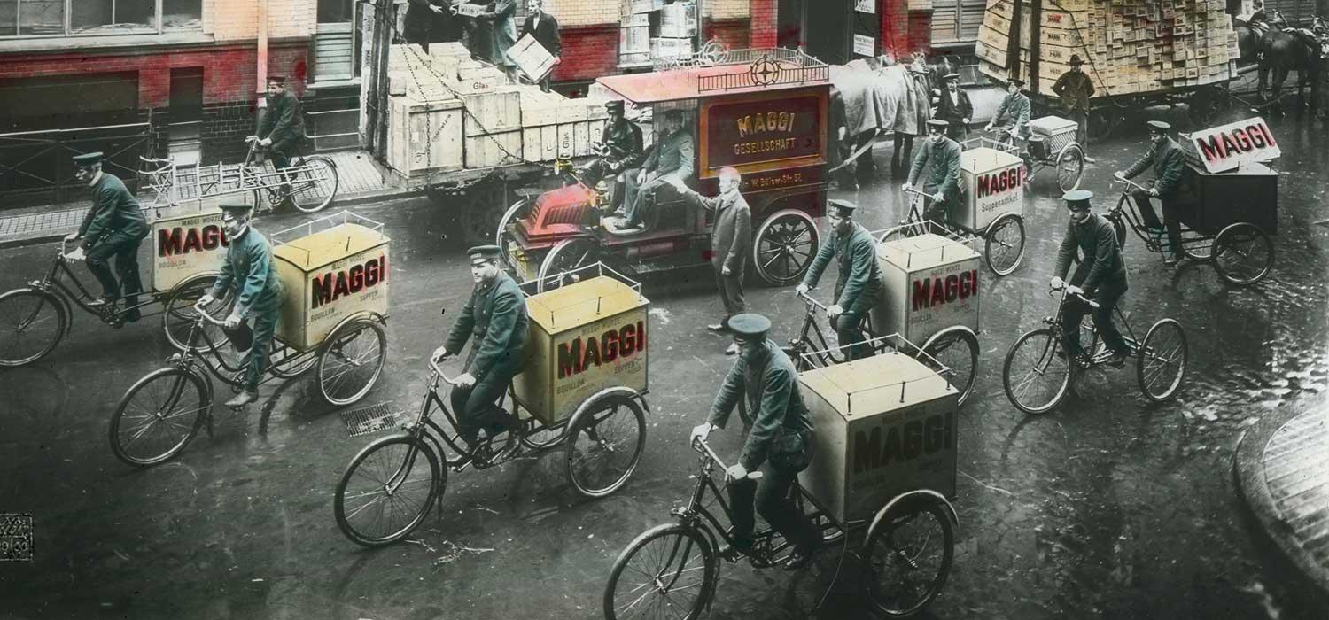 Historische Bilder von Männern auf Fahrrädern mit MAGGI Anhängern.
