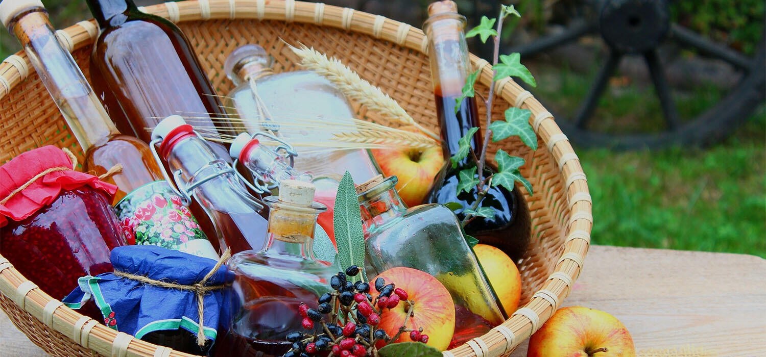 Präsentkorb mit selbstgemachter Marmelade, Essig, Öl und Sirup