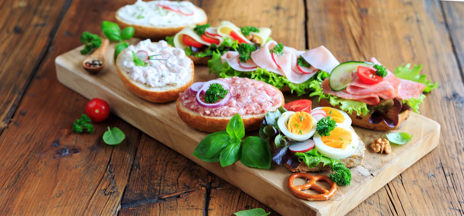 Verschieden belegte Brote schön angerichtet auf einem Brett.