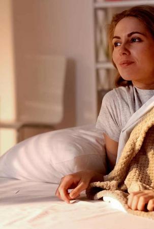 Frau im Bettkurz vorm aufstehen