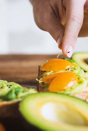 Frau bereitet ein Avocadocreme-Rezept zu