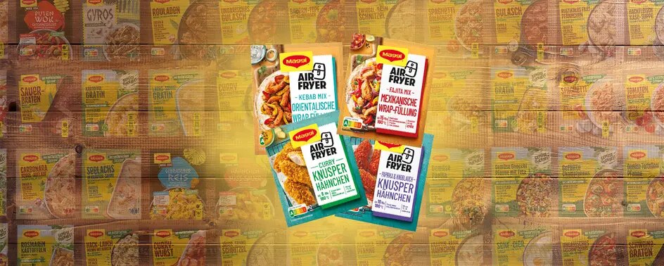 Vier Maggi Airfryer Fix Packungen für Wrap Füllung und Knusperhähnchen auf Holz, Hintergrund mit weiteren Produkten