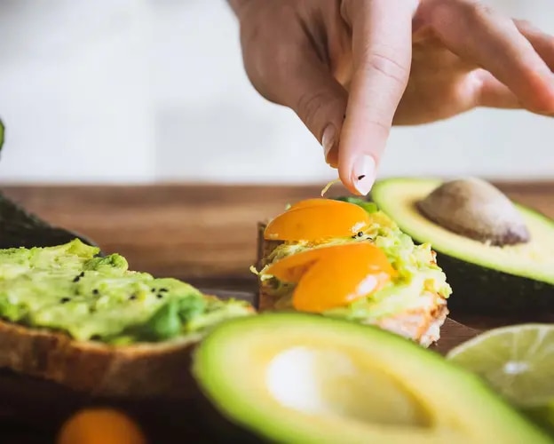 Frau bereitet ein Avocadocreme-Rezept zu