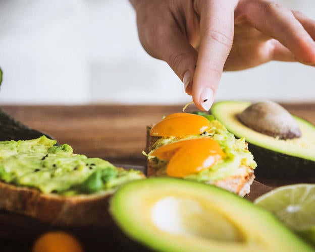 Frau bereitet ein Avocadocreme-Rezept zu