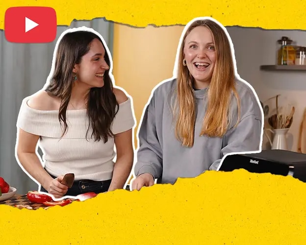 Saskia und Sofie an Küchenarbeitsplatte mit Paprika, Küchenutensilien und YouTube-Logo im Bild